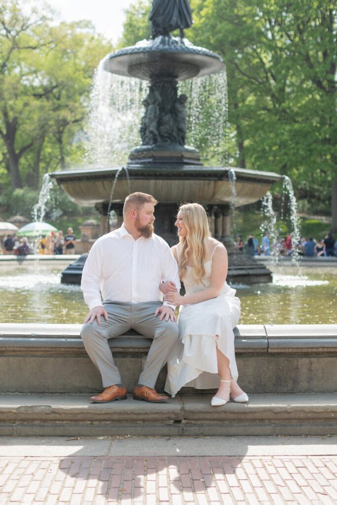 Couple sitting on Bethesda Fountain in NYC for Engagement Photos