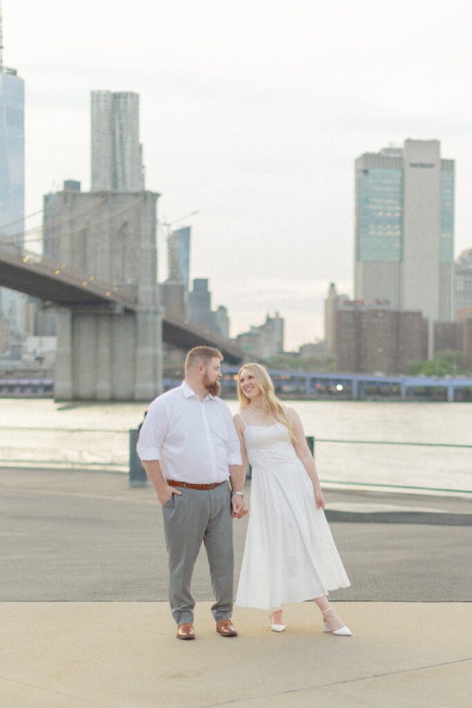 Couple at sunset in DUMBO Brooklyn during their NYC engagement session with Brooklyn Bridge views